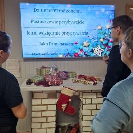 Dziewczynki i chłopiec wspólnie śpiewają kolędę.