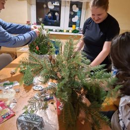 Wychowanki przystrajają żywe gałązki ozdobami.