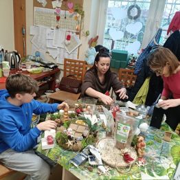 Wychowawcy z uczniem podczas pracy nad kompozycją bożonarodzeniowa. 