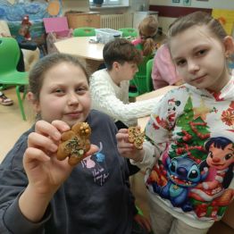 Uczennice prezentują udekorowane pierniczki. 