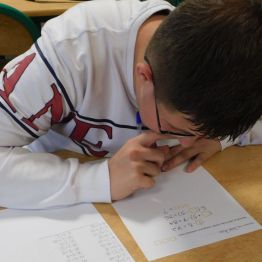 uczeń rozwiązuje zadania z tzbliczki mnożenia