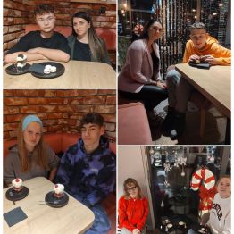 Wychowankowie spędzają czas w przytulnej kawiarni, siedząc przy stolikach z kawą i deserami w zimowo-świątecznej atmosferze.