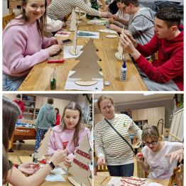 Wychowankowie wycinają, sklejają i ozdabiają drewniane choinki, panuje radosna atmosfera spotkania.