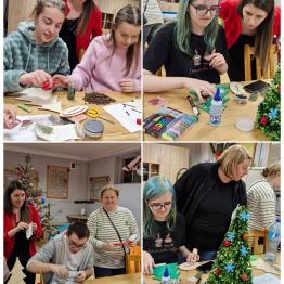 Wychowankowie spędzają wspólnie czas przy świątecznych warsztatach plastycznych – wycinają, sklejają i ozdabiają drewniane choinki, panuje radosna atmosfera spotkania.