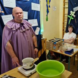 Wychowawca wróżbita przy stanowisku z tradycyjnym laniem wosku.