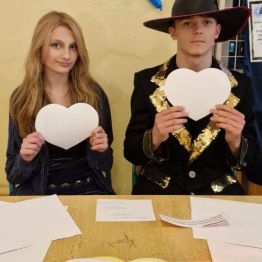 Wróżbici siedzą przy stanowisku: wróżba „Serca imion”.