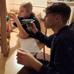 chłopiec przykleja klejem bombki na choince