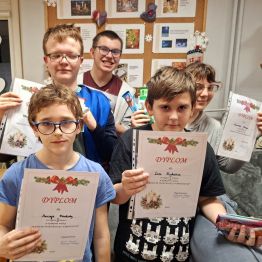 Dzieci z dyplomami i słodkimi upominkami.