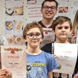 Dzieci z dyplomami i słodkimi upominkami.