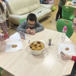 Grupa uczniów dekoruje pierniki. 