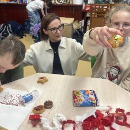 Wychowawca z uczniami podczas dekorowania pierników. 