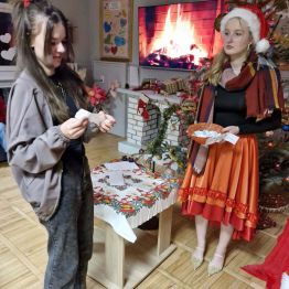 dziewczynka czyta zadanie do wykonania by otrzymać prezent od Mikołaja