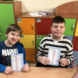 Uczniowie prezentują samodzielnie wykonane termometry.