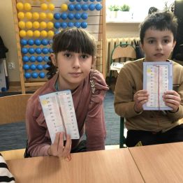 Uczniowie prezentują samodzielnie wykonane termometry.