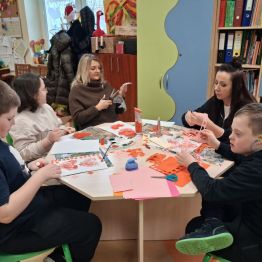 Wychowawcy z uczniami podczas wykonywania walentynkowych prac plastycznych. 