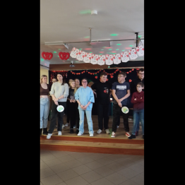 Uczniowie stoją na scenie uczestniczą w konkursie i odpowiadają na pytania