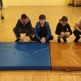 5 chłopców kuca przed materacem