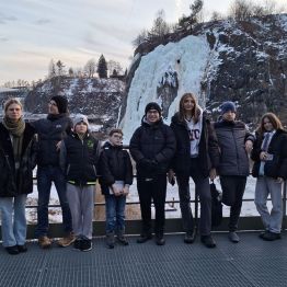 Wspólne zdjęcie wychowanków na tle lodospadu.