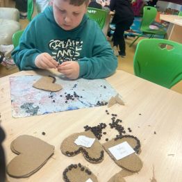 Uczeń ozdabia serce kawą.