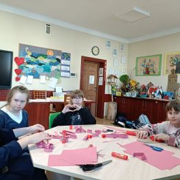 Uczniowie z wychowawcą podczas pracy nad serduszkowym łańcuchem. 