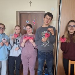 Uczniowie prezentują samodzielnie wykonane materiałowe serduszka. 