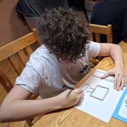 chłopiec wykonuje swoja pracę plastyczną