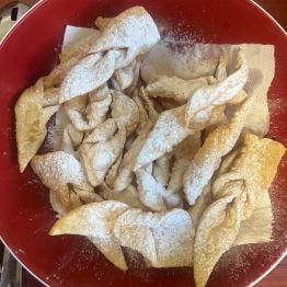 Usmażone faworki posypane cukrem pudrem. 