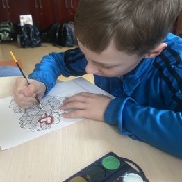 Uczeń podczas malowania walentynkowego bukietu. 