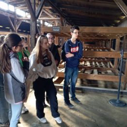 uczniowie w baraku w Brzezince słuchają pani przewodnik