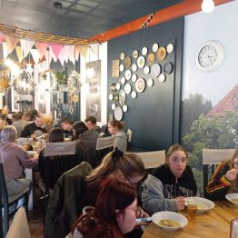 uczniowie siedzą na obiedzie