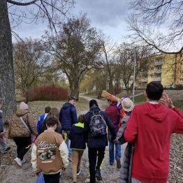 Wychowankowie idą w marszu przez park, obserwując zwiastuny nadchodzącej wiosny