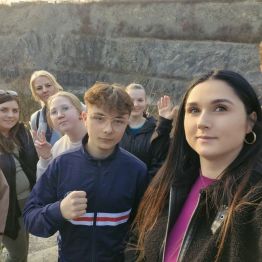 Wychowankowie z wychowawcami pozują do zdjęcia na tle "Rezerwatu Skalnego Ślichowice".