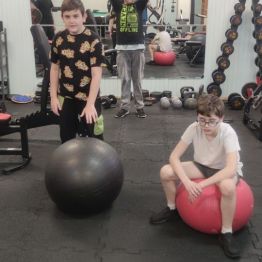 Chłopcy ćwiczą na siłowni