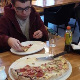 chłopiec je pizzę w restauracji