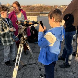 chłopiec robi zdjęcie  Słońca telefonem