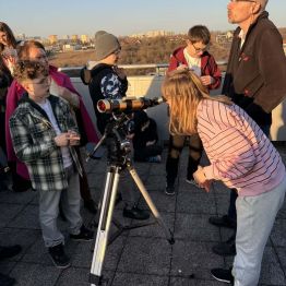 dziewczynka obserwuje niebo przez teleskop