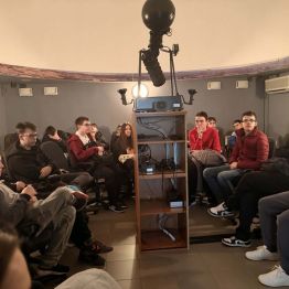 dzieci siedzą w Planetarium czekają na oglądanie nieba nocą