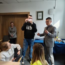 Pan i chłopiec pokazują eksperyment z pieniędzmi.