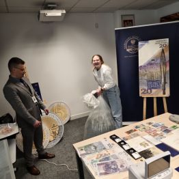 Dziewczynka próbuje podnieść worek z pieniędzmi.