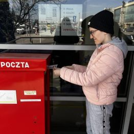 Malwinka wrzuca list do skrzynki pocztowej.