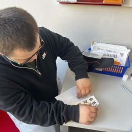 Dawid chowa widokówkę do koperty.