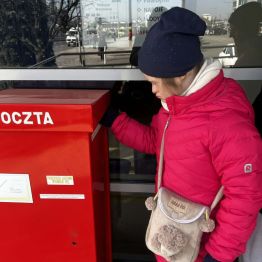 Kasia wrzuca list do skrzynki pocztowej.