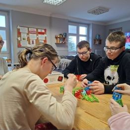 Wychowankowie układają piramidę z krzeseł. 