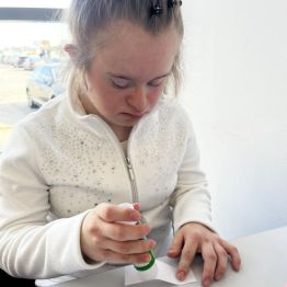 Kasia smaruje klejem kartkę z adresem.