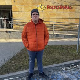 Kamil stoi przed pocztą.
