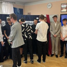 Koledzy z klas czwartych wręczają upominki absolwentom.