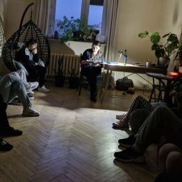 Wychowawca siedzi przy biurku - czyta bajkę, przy dźwiękach muzyki wychowankowie leżą na pufach, wczuwają się w opowieść i odprężają się.