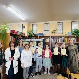 Laureaci konkursu z klas IV-VI SP z Paniami Dyrektor i organizatorkami konkursu. W tle regały z książkami.