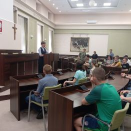 Uczniowie siedzą w sali obrad i słuchają pani prezydent