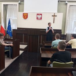 Uczniowie siedzą w sali obrad i słuchają pani prezydent